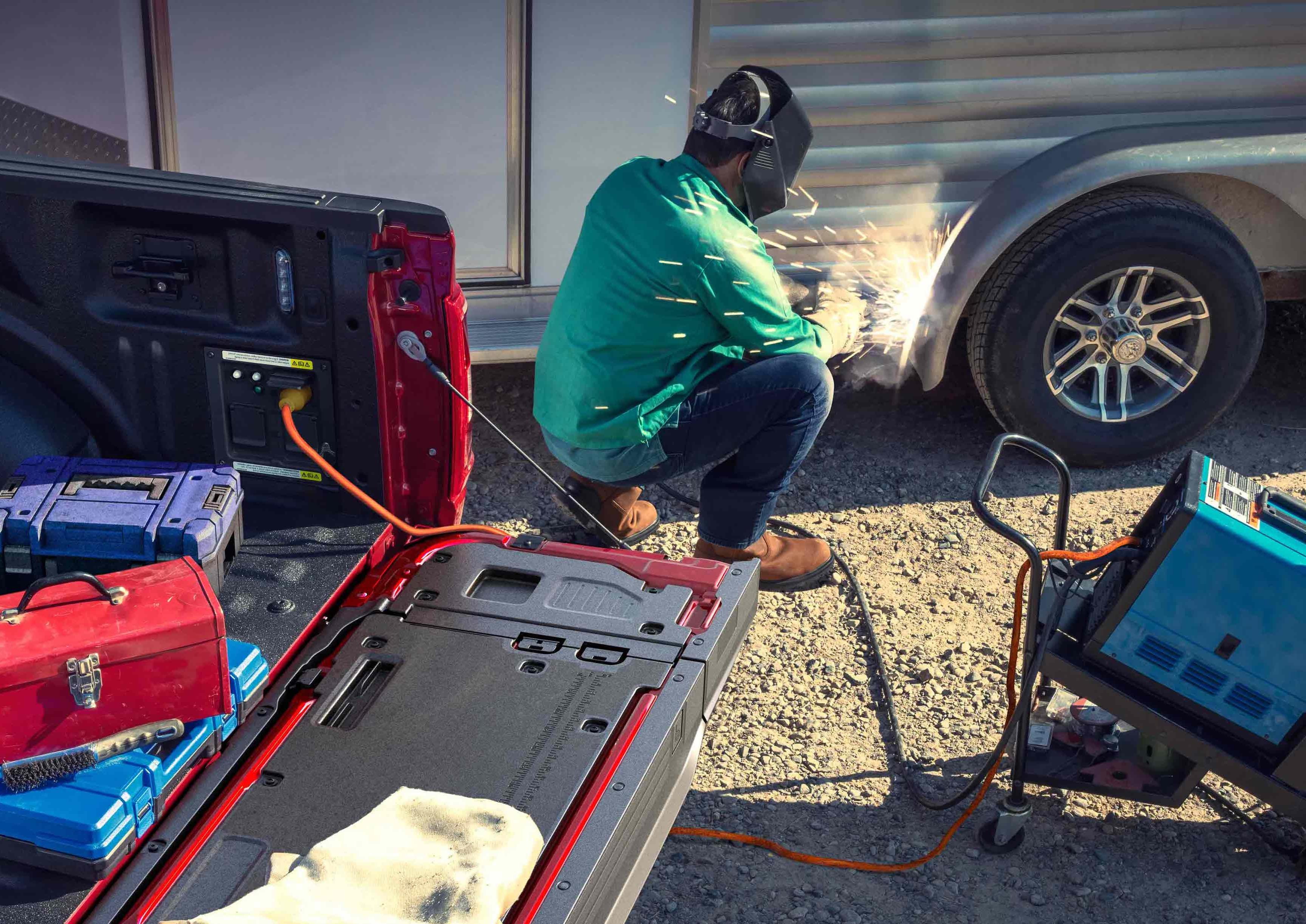 使用TIG焊机的人员，该焊机插入位于卡车床上的Pro Power Onboard功能